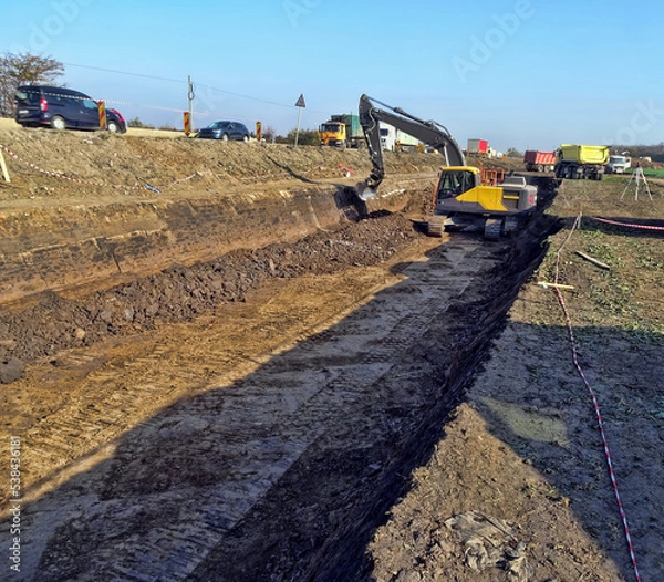 Fototapeta Excavator work on construction site at sunset