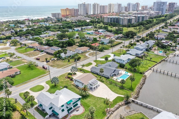 Obraz Aerial of Daytona Beach Shores residential neighborhood  in the foreground with high rise condos and hotels in the background.