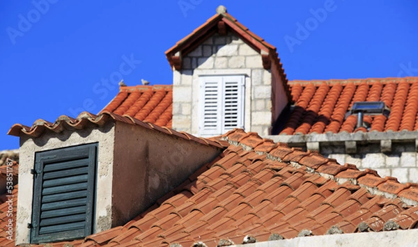 Fototapeta Terracotta roofs and dormer windows with shutters