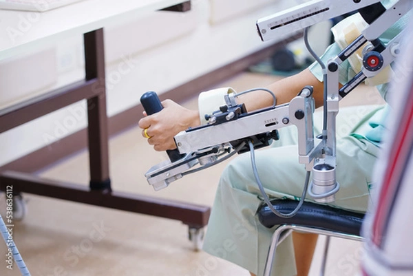 Fototapeta woman wear machine arm for physical therapy. By defining how a robot driven moving technique can be improved to achieve better results in physical rehabilitation.