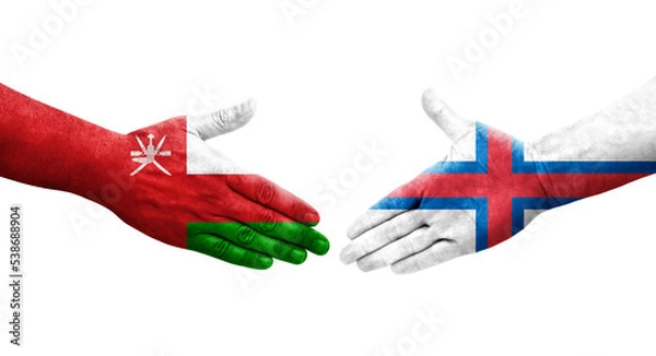 Fototapeta Handshake between Faroe Islands and Oman flags painted on hands, isolated transparent image.