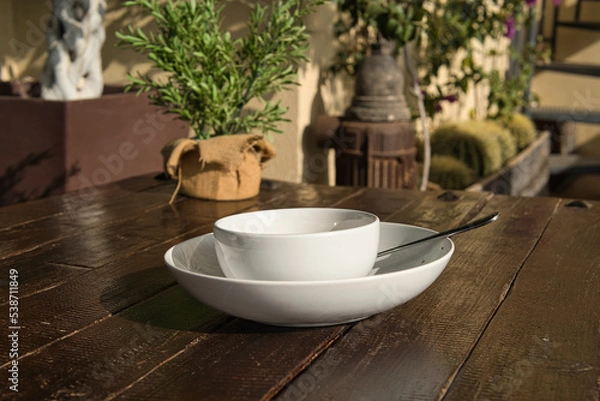 Fototapeta cup of soup with white plate on wooden table
