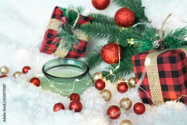 Obraz Decor of green shiny Christmas balls, lights of a Christmas garland on a white fluffy soft background. Cozy holidays. New Year holidays 2023. Place for text. Postcard for the New Year and Christmas.