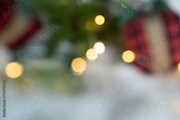 Obraz Christmas tree branch and a gift in a red package. Photo out of focus. People with poor eyesight, farsightedness. Postcard for Christmas and New Year. christmas background