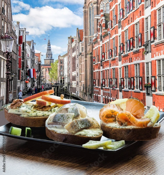 Fototapeta Amsterdam city with fish plate (salomon and codfish sandwiches) against canal in Netherlands