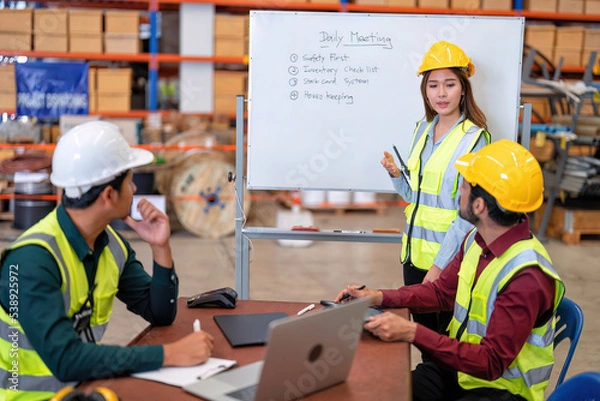 Fototapeta Group of worker in the warehouse factory conduct toolbox talk daily meeting focus on safety priority and house keeping in the morning before start working