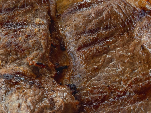 Fototapeta Detail of a well cooked grilled steak with marked lines and juicy