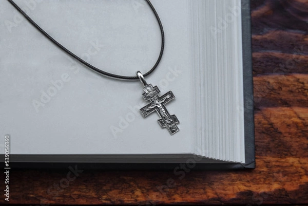 Fototapeta Religious open book bible, gospel with white pages and  cross, crucifixion close-up with an empty space for the text, copy space, the concept of faith, hope, prayer, Christianity, sins and repentance