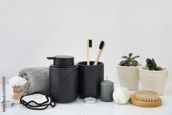 Fototapeta Set of different bath supplies with candles and houseplants on light background