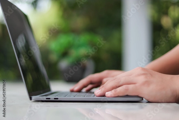 Fototapeta Asian man typing on black monitor laptop keyboard or notebook computer to check email. Prepare to present at the meeting Get information for online shopping or Internet banking operations.