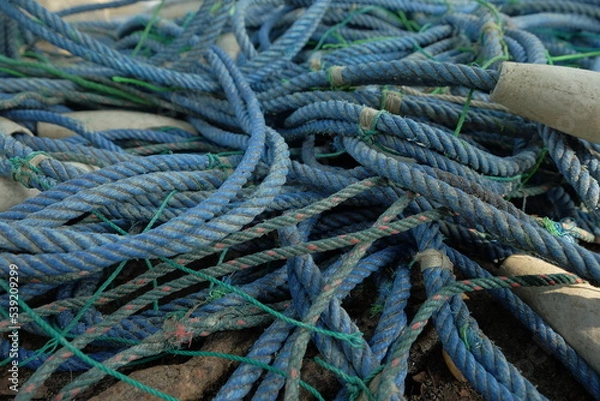 Fototapeta Detail view and background of used fishing net ropes and buoys