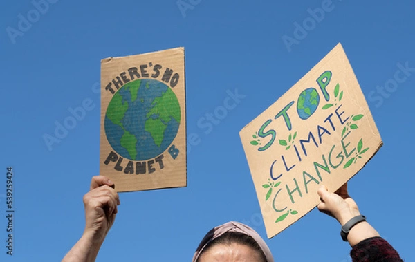 Fototapeta Protesters holding signs with slogans There's no planet B and Stop Climate Change. People with placards at protest rally demonstration, strike against global warming.