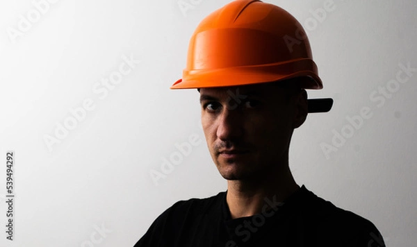 Fototapeta Confident young unshaven business man in light shirt protective construction helmet isolated on grey background. Achievement career wealth business concept. Mock up copy space.