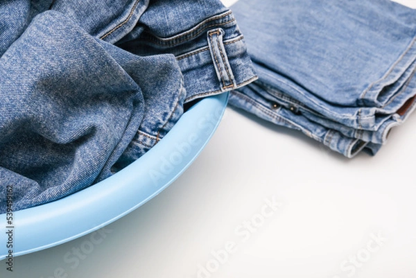 Fototapeta Jeans pants, denim in a bowl prepared for delicate hand washing, laundry concept with copy space