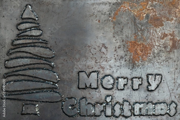 Fototapeta Hard phrase merry christmas made from steel letters welded to a steel sheet. Unusual Christmas card. Christmas card in heavy metal style. Copy space.