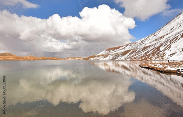 Fototapeta reflection of clouds in the sacred alpine lake Tulpak-Kul in the snow-capped Pamir mountains in Kyrgyzstan