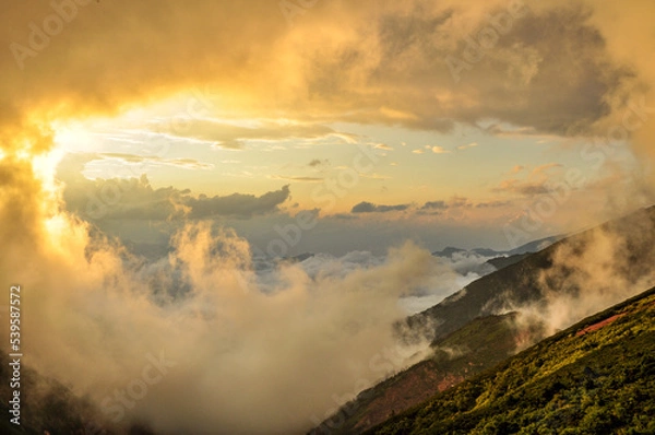 Obraz 夕焼けと霧に巻かれる北アルプスの写真（長野県）