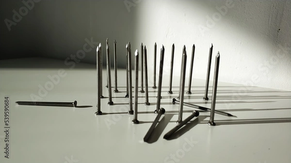 Fototapeta Lots of big new hobnails a hardware stand on hats close-up Light and shadow.