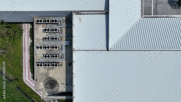 Fototapeta Bird eye view of many rooftop air compressor unit working slowly and hard on white metal sheet rooftop