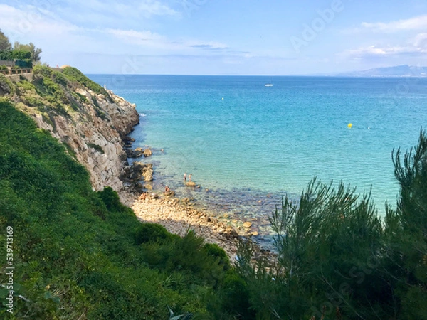 Fototapeta Salou, Spain, June 2019 - A close up of a hillside next to a body of water