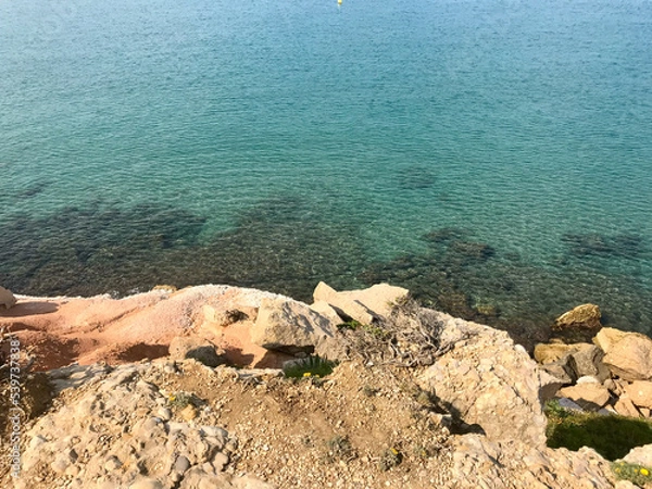 Fototapeta Salou, Spain, June 2019 - A close up of a rock next to a body of water