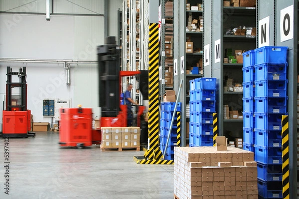 Obraz Busy warehouse with pallet trucks working