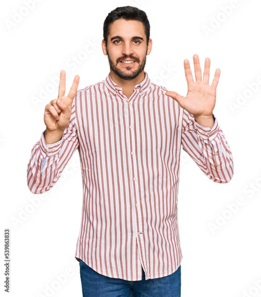 Obraz Young hispanic man wearing business shirt showing and pointing up with fingers number seven while smiling confident and happy.