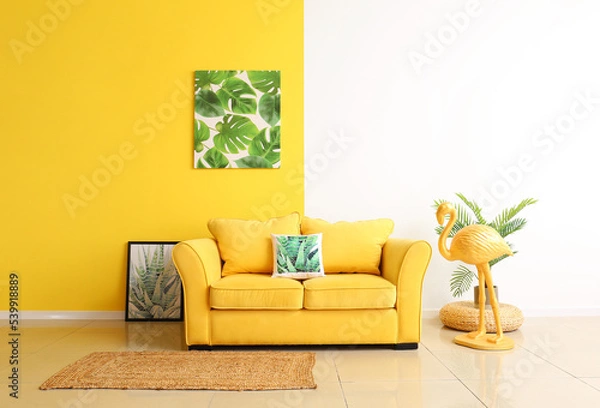 Fototapeta Interior of room with comfortable sofa, flamingo and paintings near color wall