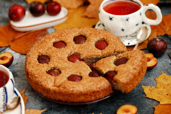 Fototapeta Plum pie. Delicious pie on a concrete table. Autumn design