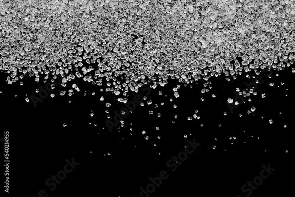Obraz Białe kryształy cukru rozsypane na czarnym tle