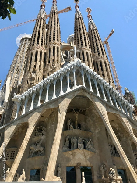 Fototapeta Barcelona, Spain, June 2019 - A large building with Sagrada Familia in the background