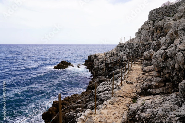 Fototapeta pathway fence walk path by sea mediterranean coast at Antibes Juan-les-Pins in France
