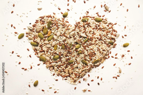 Fototapeta An object in the shape of a heart from a scattering of various seeds and grains.