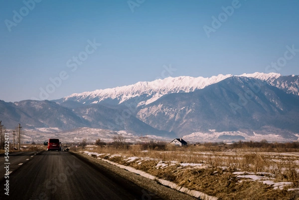 Fototapeta Panoramic view over the ski slope Poiana Brasov ski resort in Transylvania, Pine forest covered in snow on winter season,Mountain landscape in winter with the Bucegi Mountains in the background.