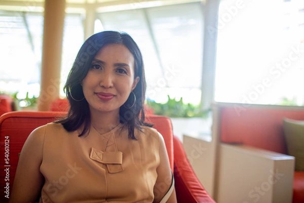 Obraz beautiful asian lady sitting on the sofa and smile at the camera