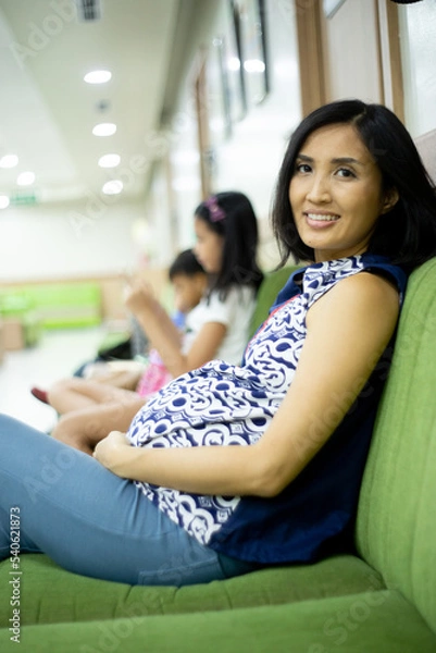 Obraz pregnant woman sitting and waiting for turn to check her baby to the doctor