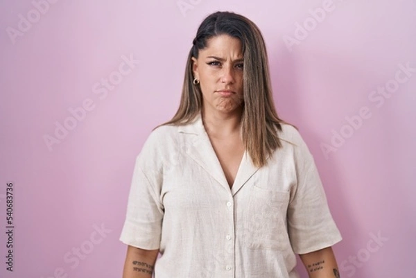 Fototapeta Blonde woman standing over pink background depressed and worry for distress, crying angry and afraid. sad expression.