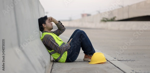 Fototapeta Asian construction workers sit stressed and anxious from working at construction sites.