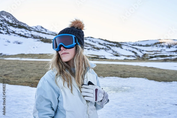 Obraz beautiful girl poses before the camera with a casual and calm appearance equipped with a hat and snow goggles