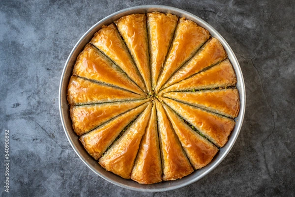 Fototapeta Carrot slice baklava with pistachio. Tray baklava on dark background. Traditional Turkish cuisine delicacies. close up