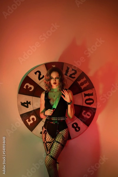 Obraz Girl in a sexy costume with a knife and a shadow with horns. halloween image