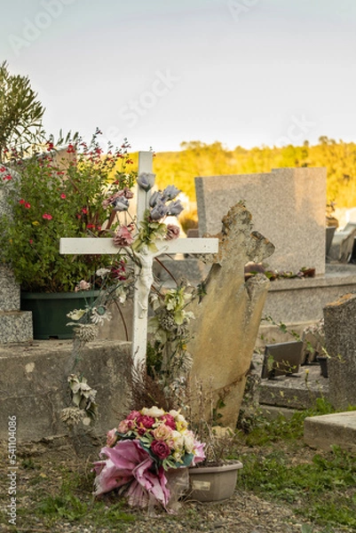 Fototapeta Old tombstone, adorned with flowers
