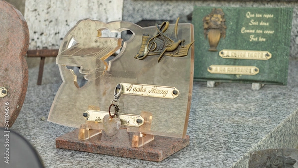 Fototapeta Transparent pink funeral plaque, decorated with a heart and a bird in flight on a musical score, with the inscription: "To our grandma"
