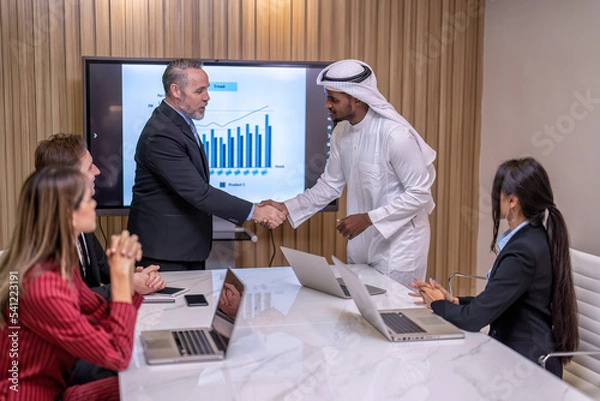 Fototapeta Group of business diversity people and middle east co-worker working in office in the meeting room one employee stand near big screen TV presentation explain the business plan to team