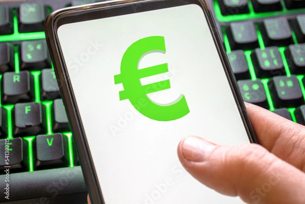 Fototapeta Smartphone with euro symbol on screen phone with technology green colored keyboard background