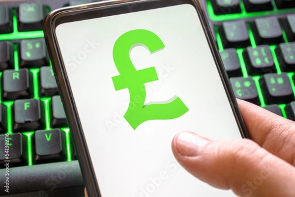 Fototapeta Smartphone with pound sterling lira symbol on screen phone with technology green colored keyboard background