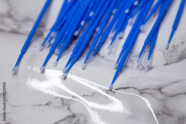 Fototapeta Set of blue microbrushes for eyelashes on a light marble background