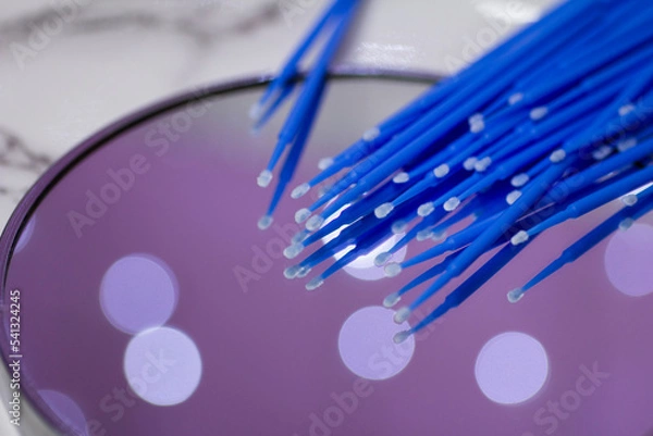 Fototapeta Set of blue microbrushes for eyelashes on a mirror background with bokeh