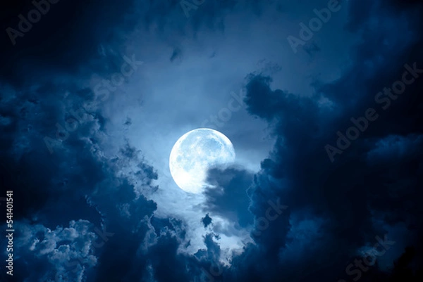 Fototapeta Night sky with full moon. Dramatic clouds in mystic moonlight. Large bright moon as concept of mystery, midnight, gothic time and spooky theme.