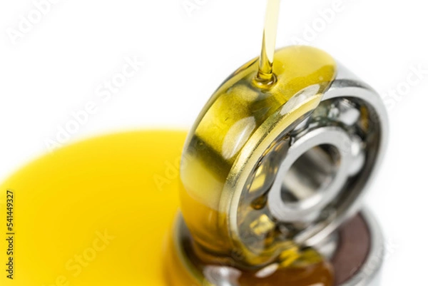 Obraz Closed up macro, Pouring automotive engine oil into ball bearing isolated on white background with copy space, engineering and industrial concept. Motor oil on bearing